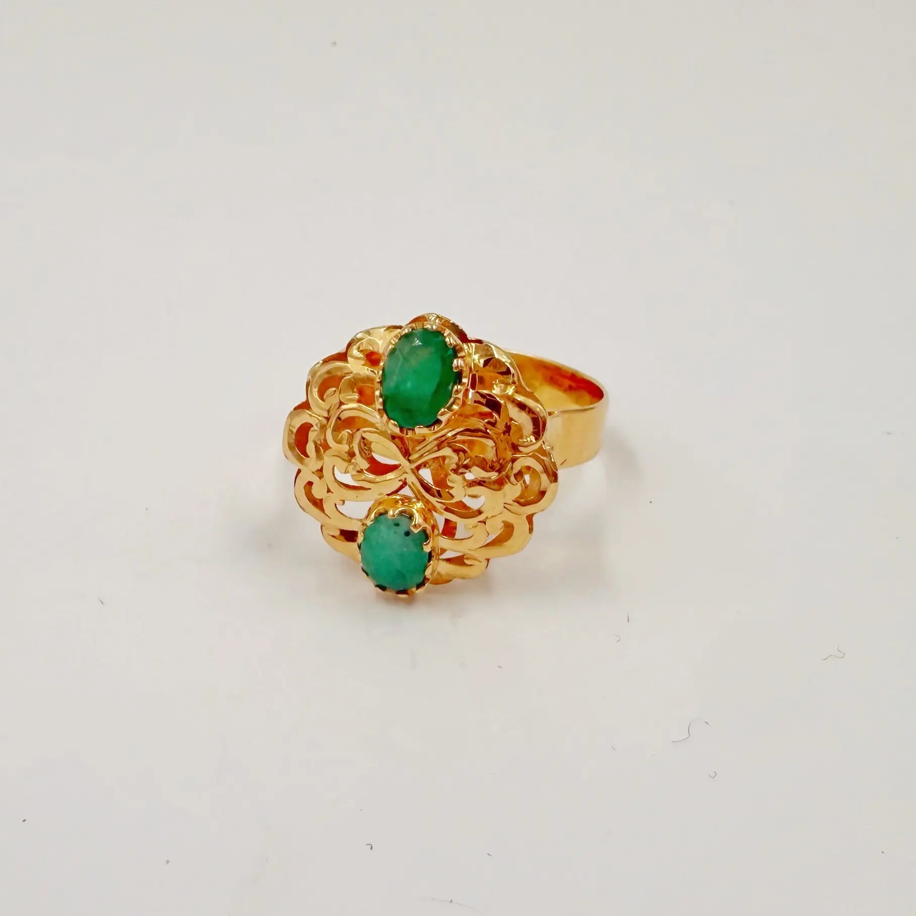 Bague traditionnelle en or rose sertie de pierres vertes