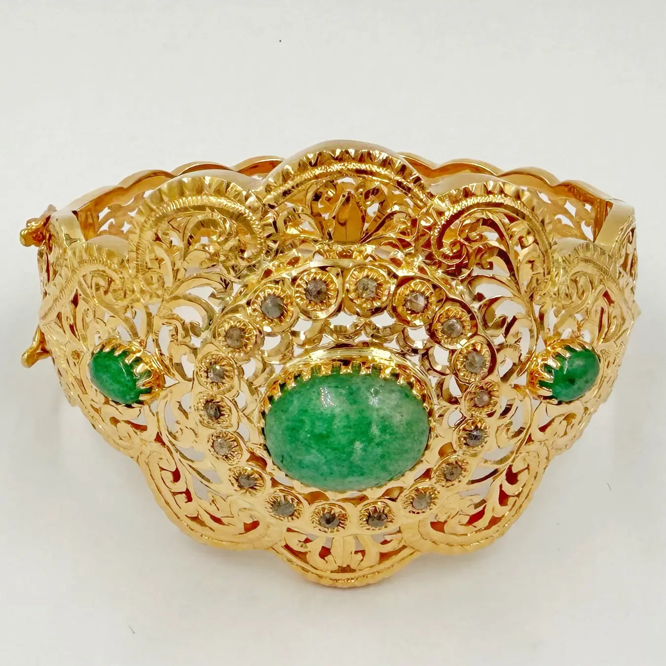 Manchette traditionnelle en or rose sertie de rosaces et de pierres vertes