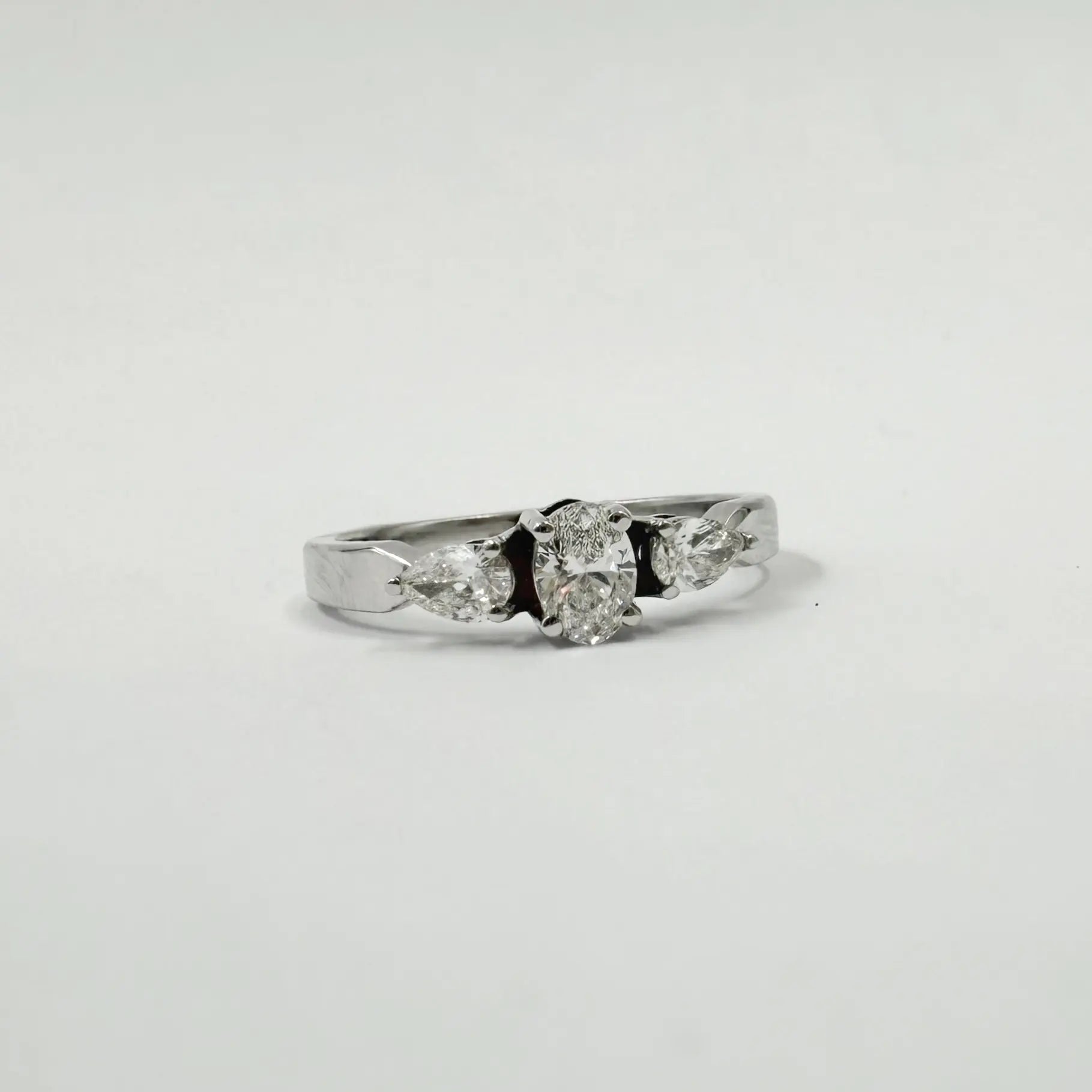 Alliance trilogie en or gris sertie d'un diamant ovale 0,30 ct et de deux diamants poire 0,30 ct