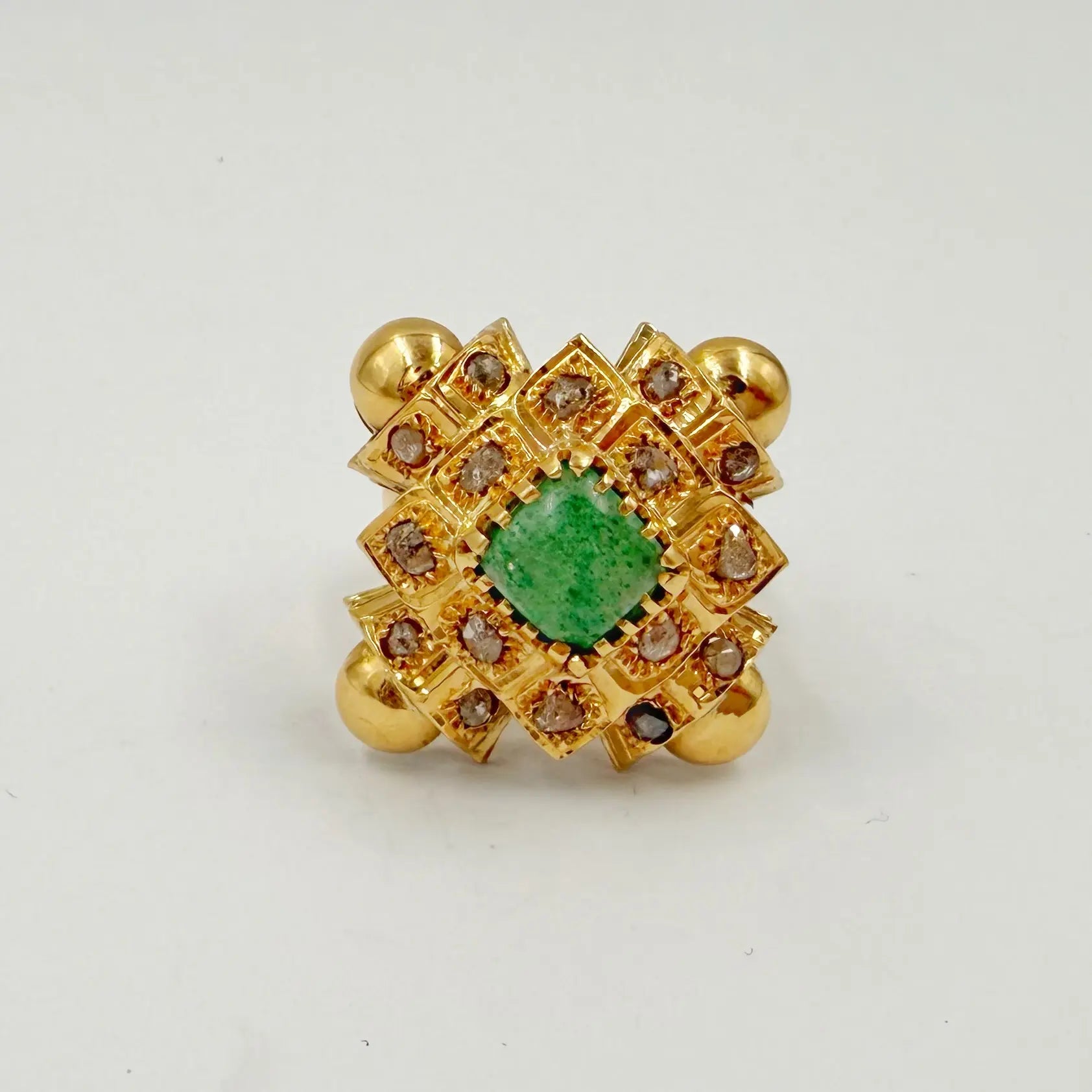 Bague traditionnelle en or rose sertie de rosaces et d'une pierre verte