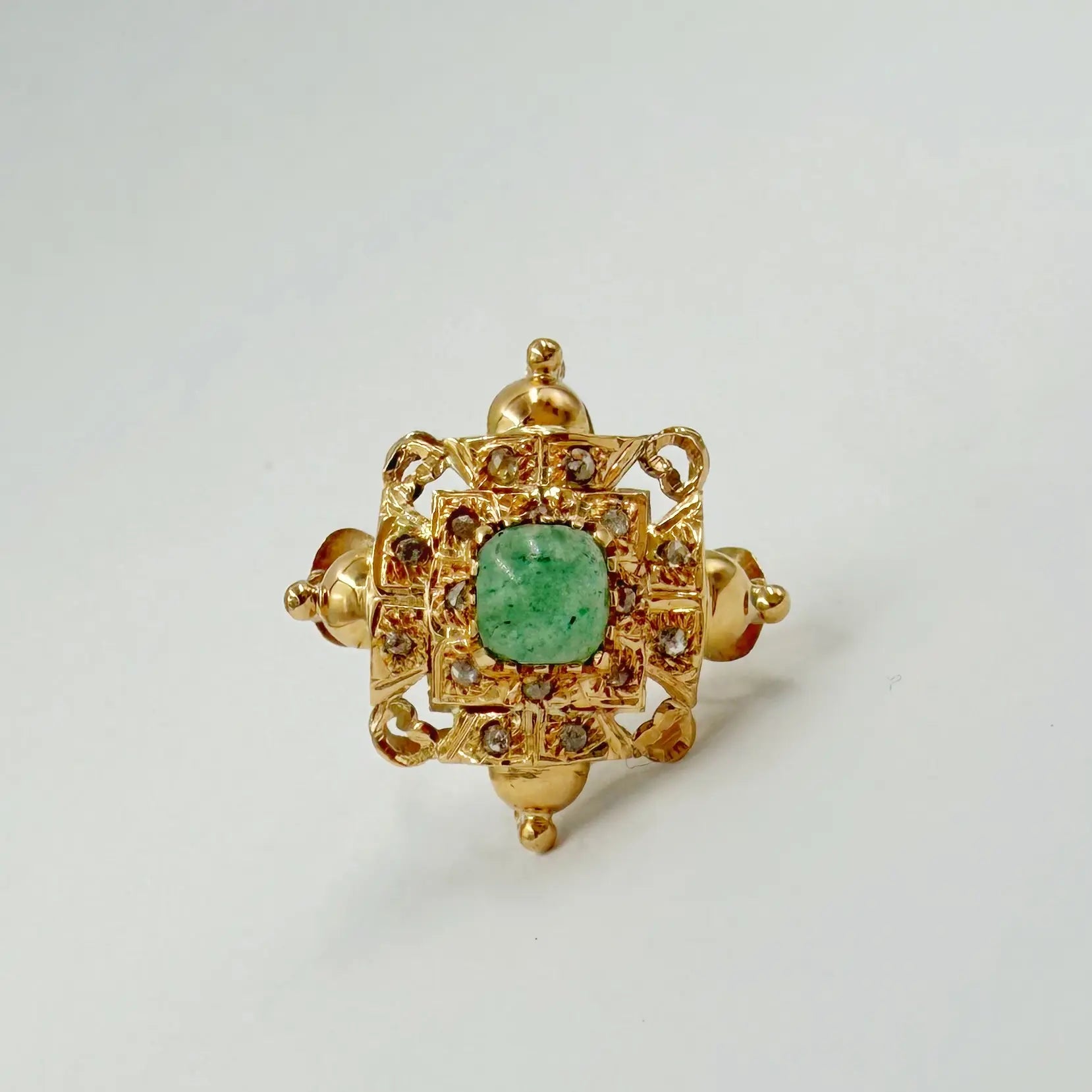 Bague traditionnelle en or rose sertie de rosaces et d'une pierre verte carrée